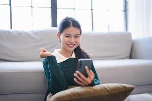 Young woman user customer hold smart phone Social media addiction with finger rings using online app on mobile phone browsing Internet chatting on social media. photo