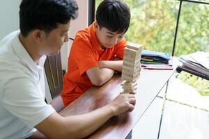 asian father and son playing with wooden blocks photo