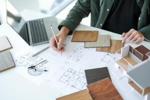 a man is working on a project with architectural plans. photo