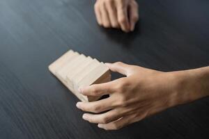 a person is holding a wooden block on a table photo