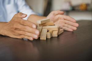 Planning risk and strategy in businessman gambling placing wooden block.Business concept photo