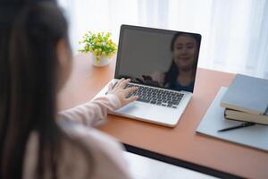a woman is using a laptop computer with a vdo chat photo