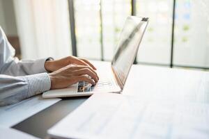 Businessman working using laptop computer Hands typing keyboard. Professional investor working start up project. business planning in office, Technology business photo