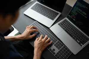Asian man software engineer Working on Computer at office desk for writing program code IT Software Engineer finding errors tech support creating digital photo