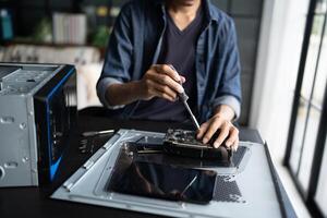 a engineer working on a computer with a screwdriver photo