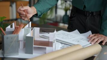 a man is working on a model of a house. photo