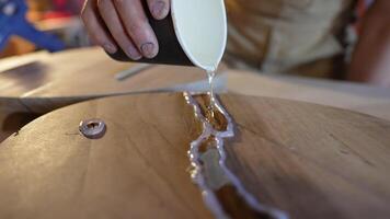 Epoxy resin poured into fine wood cracks, secured with hot glue barriers. Precise containment video