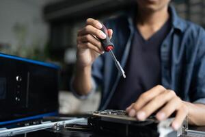 engineer is working on a computer with a screwdriver photo