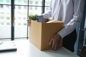 Businessman sending resignation letter and packing Stuff Resign Depress or carrying business cardboard box Change of job from company resign photo