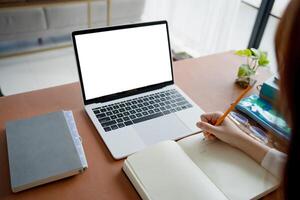 Students sitting at desk using laptop blank screen computer working in office mockup image blank screen computer white background photo