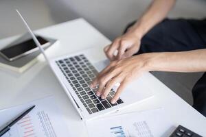 Business man working using laptop computer Hands typing keyboard. Professional investor working start up project. business planning in office. Technology business Concept. photo