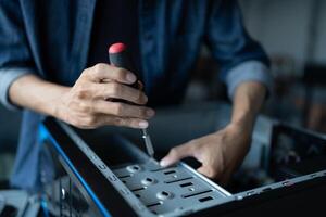 a person is fixing a computer with a screwdriver photo