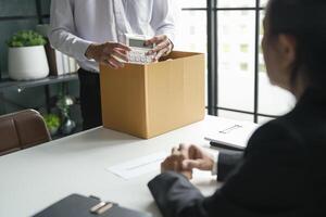 Business man sending resignation letter and packing Stuff Resign Depress or carrying business cardboard box Change of job or fired from company photo
