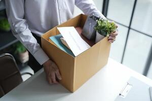 Business man sending resignation letter and packing Stuff Resign Depress or carrying business cardboard box Change of job or fired from company resign concept photo