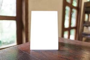 a blank white menu on a table in front of a window photo