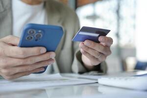 Asian Man paying with credit card on smart phone at office. photo
