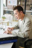 a man in a suit is working on paperwork photo