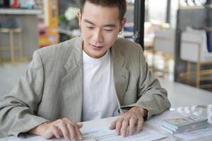 asian man in suit sitting at table with papers photo