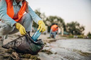 On, the, shore. ,,A volunteers collects garbage on a muddy beach photo