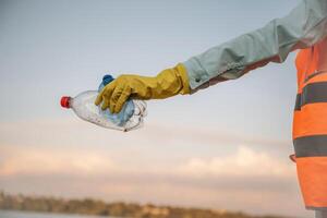 Trash, pollution. Close ,up view of female volunteer that is holding plastic bottle. photo