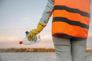 Trash pollution,. Close up view of female volunteer that is holding plastic bottle. photo