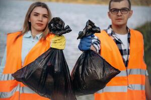 A volunteers collects garbage on a ,muddy beach photo