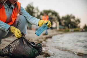 On ,the ,,,shore. A volunteers collects garbage on a muddy beach photo