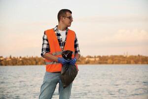 Man volunteer, is against Earth pollution by trash, outdoors photo