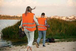 A, volunteers collects garbage on a muddy beach photo