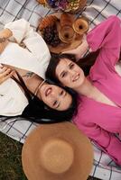 Top ,view, lying ,,down. Lesbian couple is together on the picnic in nature photo