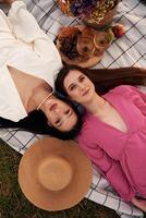 Top ,,view, lying down. Lesbian couple is together on the picnic in nature photo