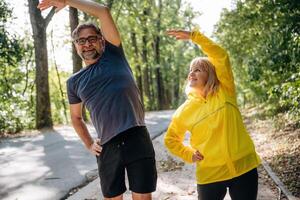 Warm, up ,exercises, ,,doing sport. Senior couple together outdoors at nature photo
