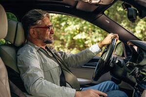 Side view of senior man that ,is,, driving a car photo