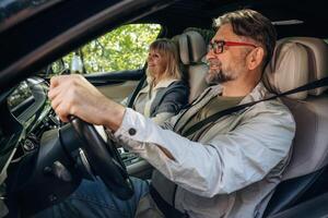 Senior ,couple, driving ,in ,,the modern car at summertime photo