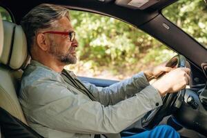 Side ,view of senior man that is driving a car photo