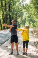 On the sidewalk. .Doing fitness exercises. Senior couple together outdoors at nature photo