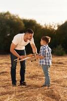 Father, and ,son ,are with wooden toy plane on the field photo