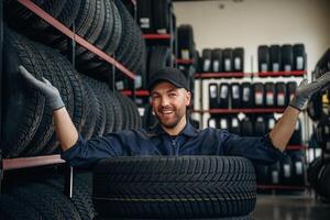 Inside of the wheels, having fun., Man worker is maintenance station with tires photo
