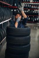 Fun, pretending to dive inside the wheels. ..,Man worker is maintenance station with tires photo