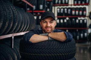 Inside ,,of the wheels, having fun. Man worker is maintenance station with tires photo