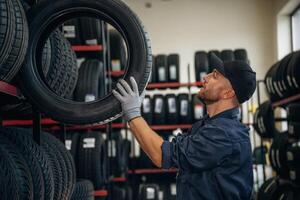 Bunch,, of tires, wheels. Man worker is maintenance station photo