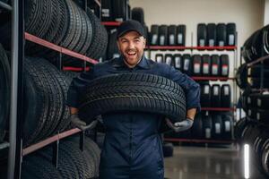 Holding ,the wheel. Man worker is maintenance station with tires photo