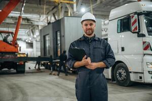 Front view, standing. Male worker, is, in ,the, modern warehouse or manufacturing company photo