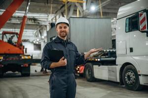 Front view,, standing. Male ,worker, is in the modern warehouse or manufacturing company photo