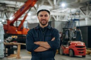 Front view,, standing. Male worker is in the modern warehouse or manufacturing company photo