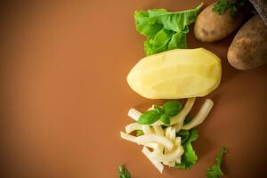 Potatoes in a sack and sliced into strips on a brown background photo
