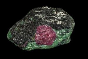 Macro of mineral, stone ruby, in rock on black background photo