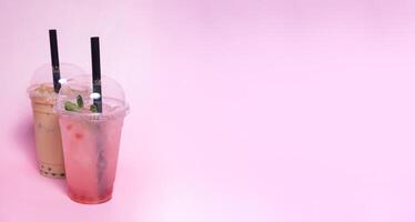 Two plastic glasses with bubble tea and ice with copy space photo