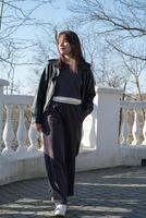 Young woman walks confidently along a scenic path in a park on a sunny day photo