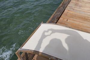 Shadow heart formed by hands on a sun lounger by the sea during a sunny day photo